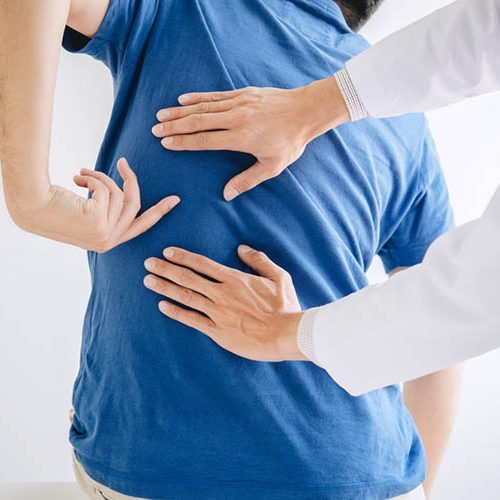 physiotherapist rubbing a patients back