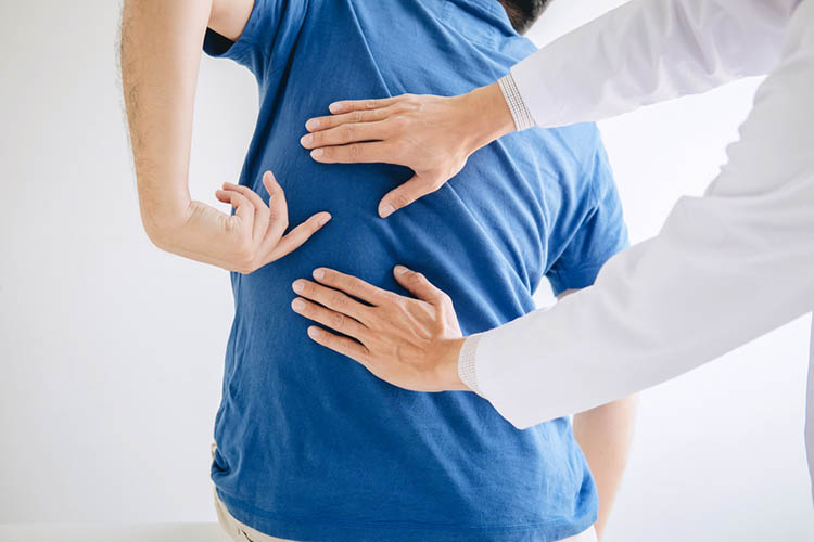 physiotherapist rubbing a patients back